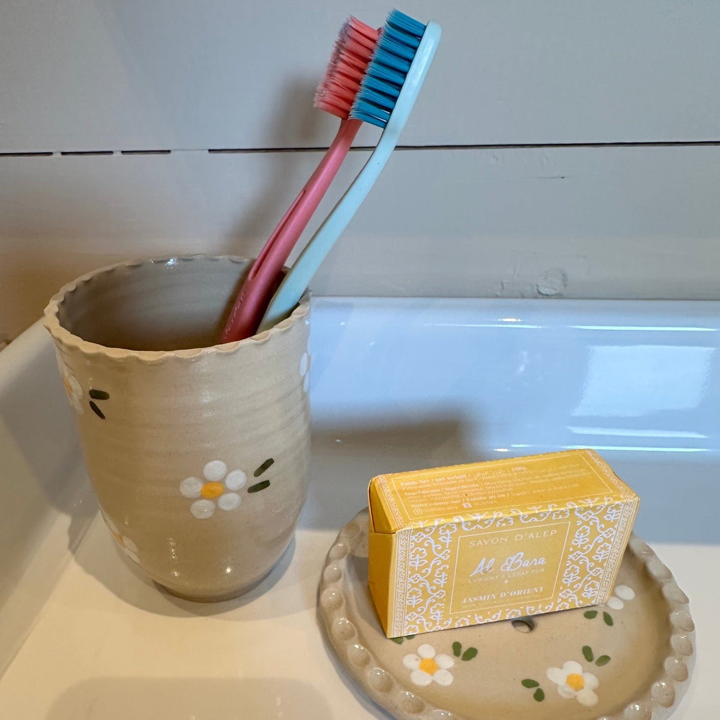 Tandborstglas med vita blommor