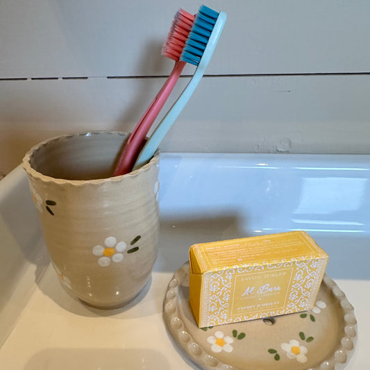 Tandborstglas med vita blommor